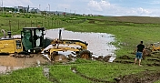Alaca'da sele müdahale eden iş makinesi toprağa saplandı